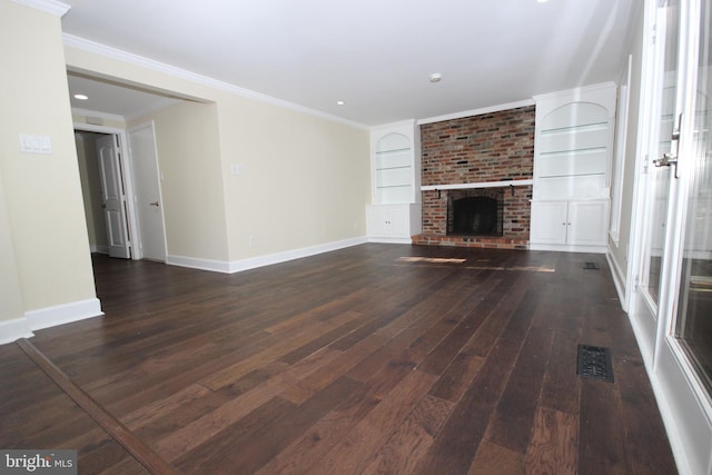 unfurnished living room featuring visible vents, built in shelves, dark wood-type flooring, baseboards, and ornamental molding