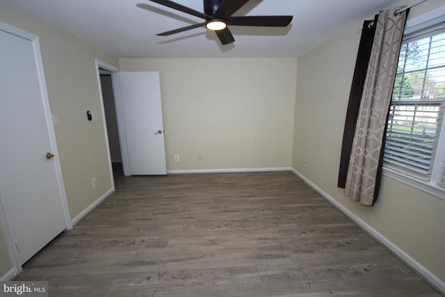 unfurnished bedroom featuring ceiling fan, baseboards, and wood finished floors