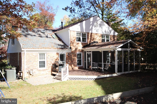 back of house featuring central air condition unit, a lawn, a sunroom, brick siding, and a patio area