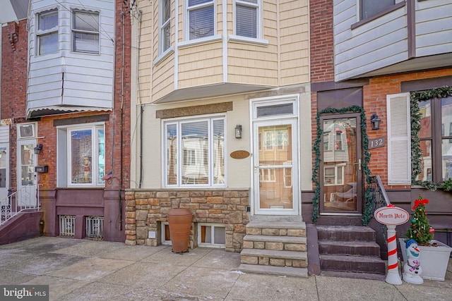 property entrance featuring stone siding