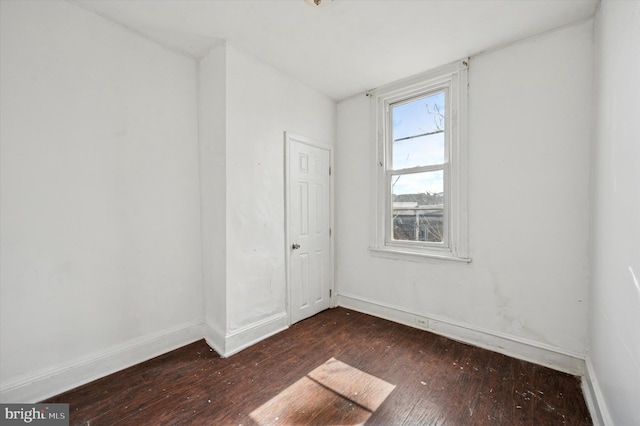 unfurnished room with baseboards and hardwood / wood-style flooring