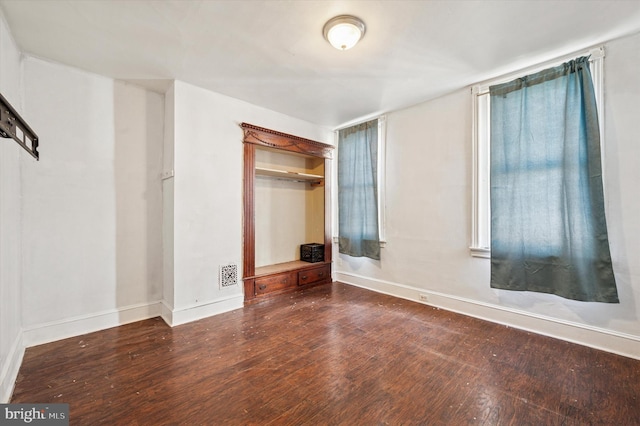 unfurnished bedroom with hardwood / wood-style floors, baseboards, and visible vents