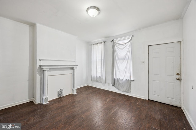 unfurnished living room with a fireplace, wood finished floors, and baseboards