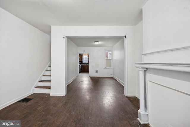 interior space with stairway, visible vents, baseboards, and wood-type flooring