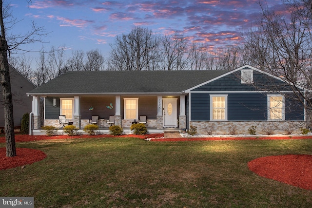 view of front facade with stone siding, a porch, and a front yard