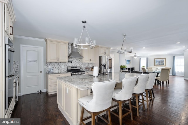 kitchen with tasteful backsplash, appliances with stainless steel finishes, wall chimney exhaust hood, and dark wood finished floors