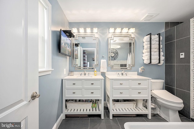 bathroom featuring visible vents, toilet, tile patterned flooring, baseboards, and vanity