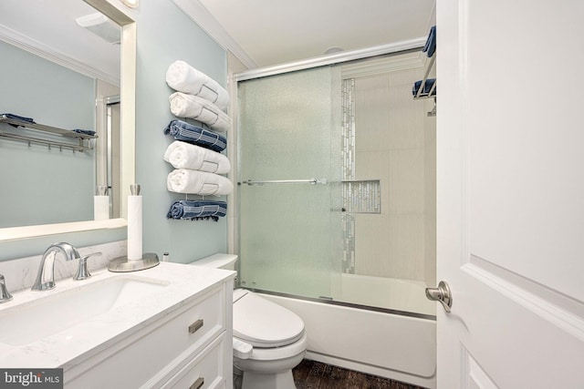 full bath with toilet, ornamental molding, wood finished floors, enclosed tub / shower combo, and vanity