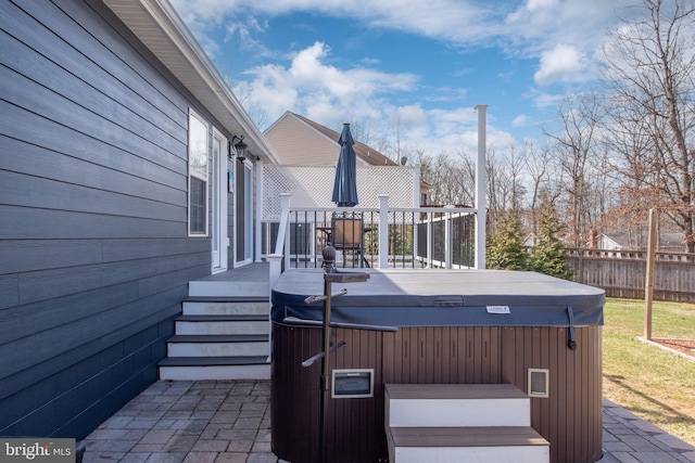 wooden terrace featuring a hot tub and fence