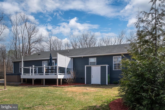 back of house featuring a yard, roof with shingles, and a wooden deck