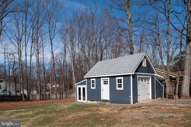 view of outbuilding featuring fence and french doors