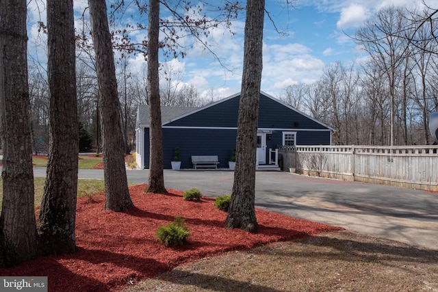 view of front of home featuring driveway and fence