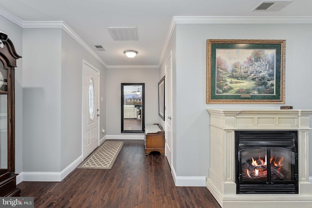 entryway with dark wood finished floors, visible vents, a warm lit fireplace, and baseboards