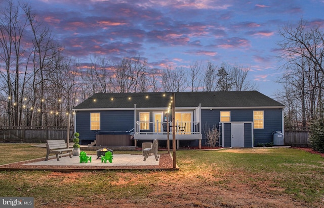 back of property featuring a wooden deck, fence, a lawn, and a patio area