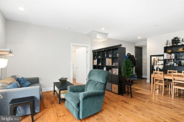 living room featuring recessed lighting, light wood-type flooring, and baseboards