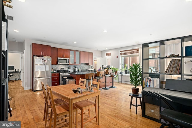 dining area featuring light wood finished floors, visible vents, and recessed lighting