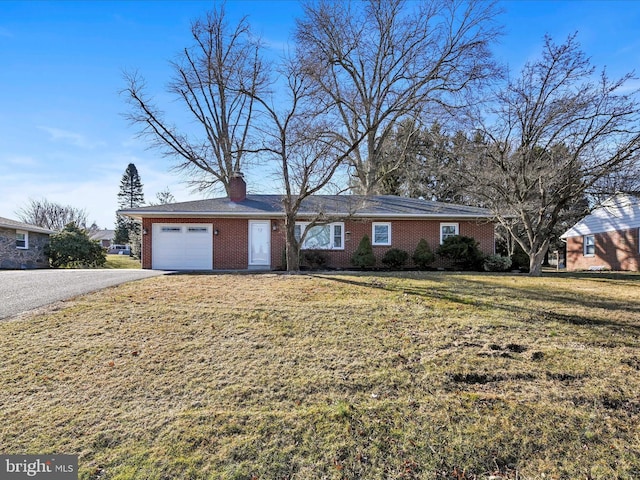 ranch-style home featuring aphalt driveway, brick siding, a garage, and a front yard