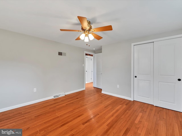 unfurnished bedroom with light wood finished floors, visible vents, ceiling fan, baseboards, and a closet