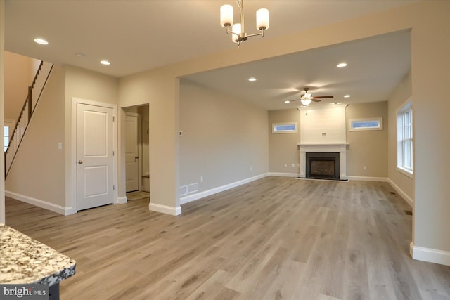 unfurnished living room with recessed lighting, a fireplace, light wood-type flooring, and baseboards