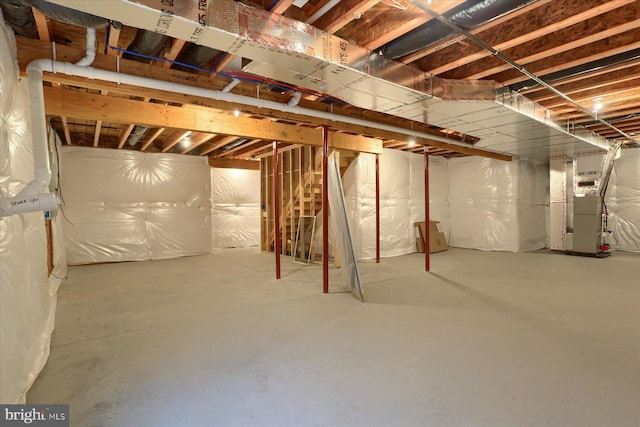 unfinished basement featuring heating unit