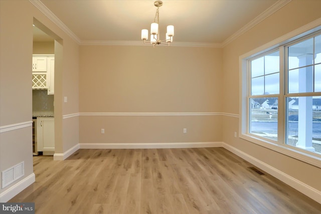 unfurnished room featuring visible vents, light wood-type flooring, and baseboards