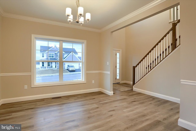 entryway featuring an inviting chandelier, ornamental molding, stairs, and light wood finished floors