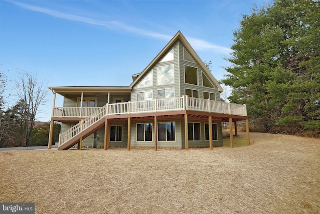 back of house featuring stairs and a wooden deck