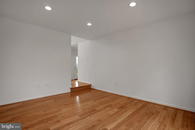 spare room with recessed lighting, baseboards, and light wood-style floors