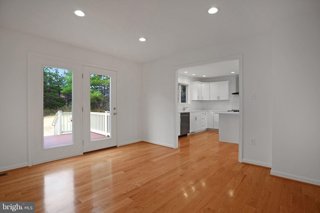 unfurnished living room with recessed lighting, light wood-type flooring, baseboards, and visible vents