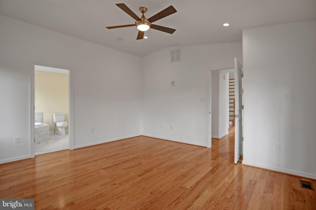 empty room with visible vents, lofted ceiling, light wood-style floors, and ceiling fan