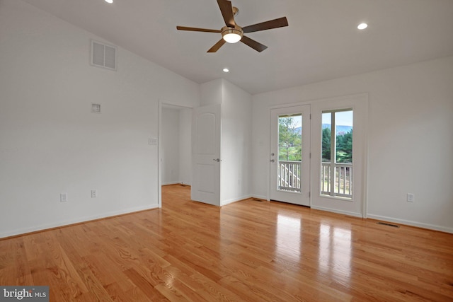 unfurnished room featuring visible vents, baseboards, light wood-type flooring, and lofted ceiling