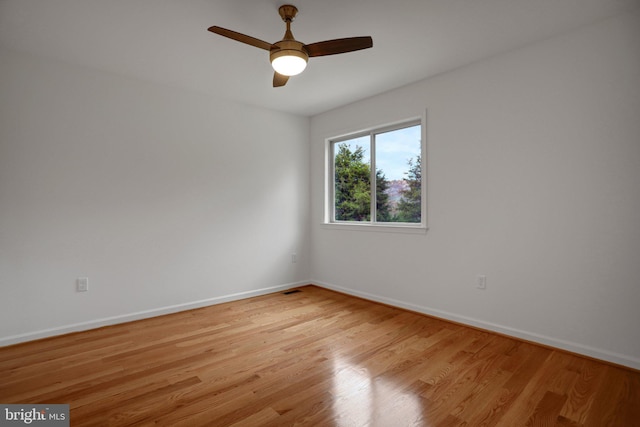 spare room featuring visible vents, baseboards, light wood-style floors, and ceiling fan