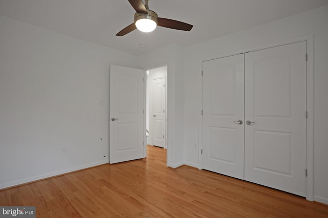 unfurnished bedroom with light wood finished floors, ceiling fan, a closet, and baseboards