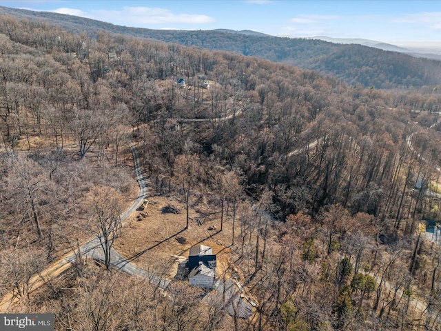 drone / aerial view featuring a mountain view and a view of trees