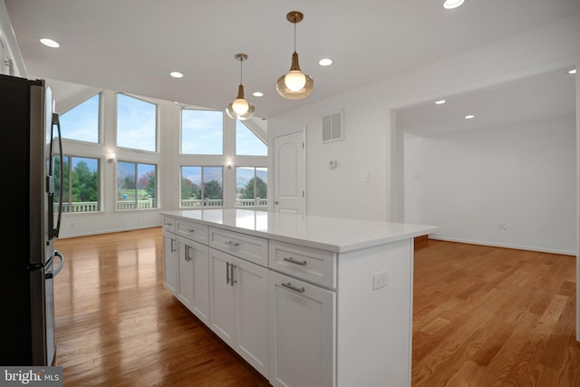 kitchen with white cabinetry, light wood finished floors, visible vents, and freestanding refrigerator