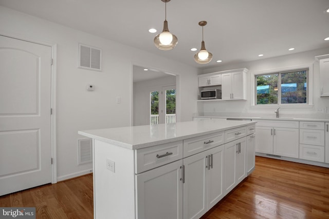 kitchen featuring stainless steel microwave, light countertops, visible vents, and a healthy amount of sunlight