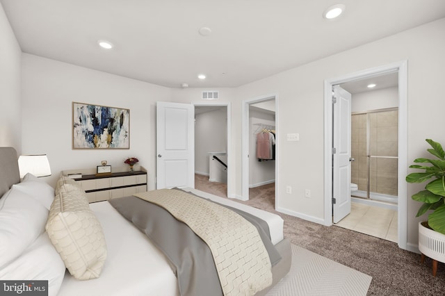 carpeted bedroom with a spacious closet, recessed lighting, ensuite bathroom, and baseboards