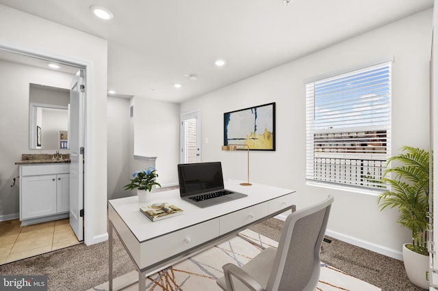 office space with recessed lighting, a healthy amount of sunlight, and a sink