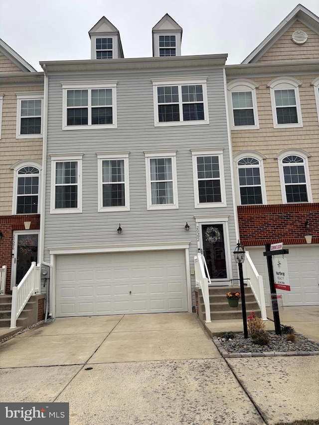 townhome / multi-family property with an attached garage and driveway