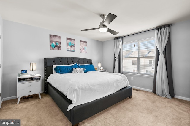 bedroom featuring light carpet, a ceiling fan, and baseboards