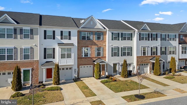 townhome / multi-family property featuring a residential view, brick siding, and driveway