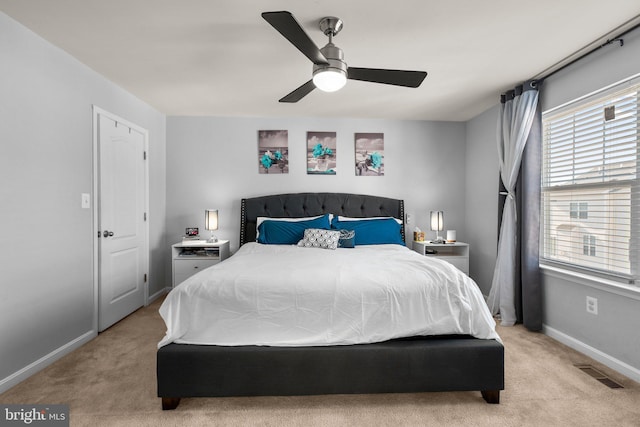 bedroom featuring visible vents, baseboards, light colored carpet, and a ceiling fan