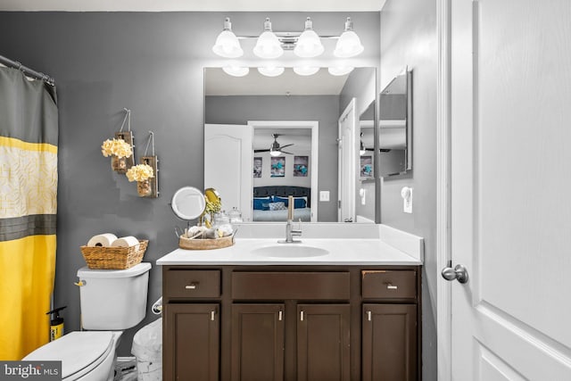 bathroom with ensuite bath, ceiling fan, vanity, and toilet