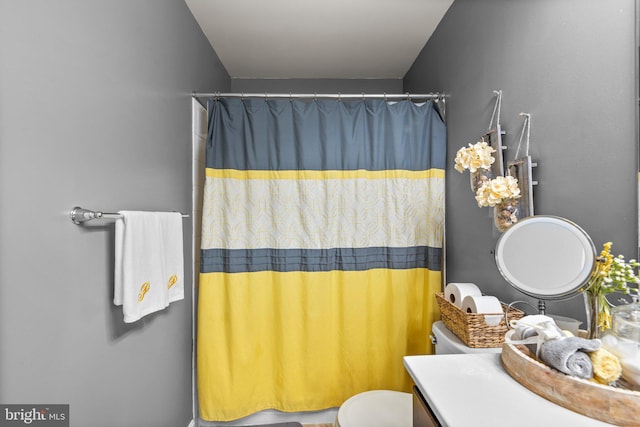 full bathroom featuring toilet, vanity, and a shower with curtain