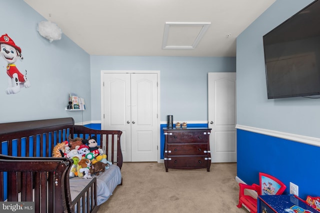 carpeted bedroom with a closet and attic access