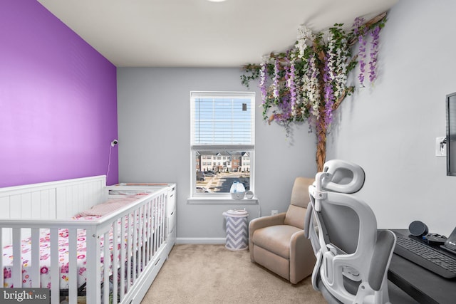 bedroom featuring a nursery area, baseboards, and light colored carpet