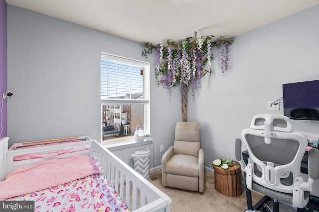 bedroom featuring a nursery area, baseboards, and light colored carpet