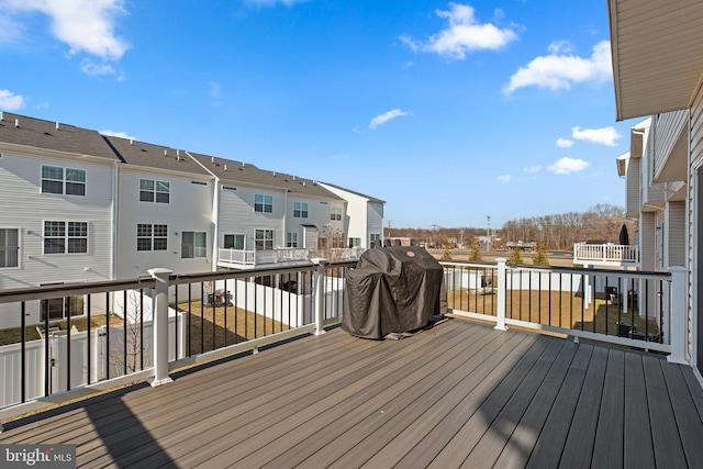 wooden terrace featuring area for grilling and a residential view