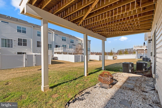 exterior space with cooling unit, a fire pit, and a fenced backyard