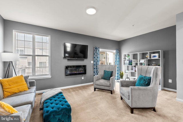 living room featuring carpet, baseboards, and a healthy amount of sunlight